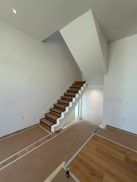 Stairway featuring wood finished floors and recessed lighting