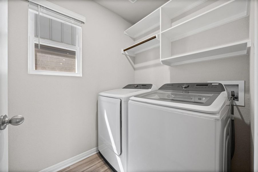 Functional built-in shelving and overhead storage maximize utility inside this modern laundry space.