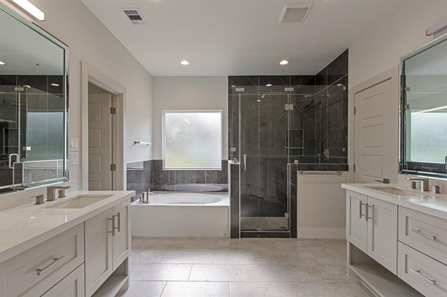 Luxurious primary bathroom with a spa-like feel and soft-close drawers.