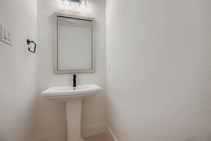 Bathroom featuring baseboards and a textured wall