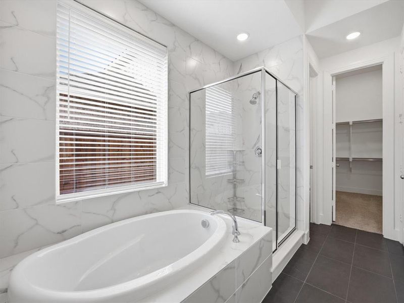 Full bath with a marble finish shower, a bath, a walk in closet, dark tile patterned flooring, and recessed lighting