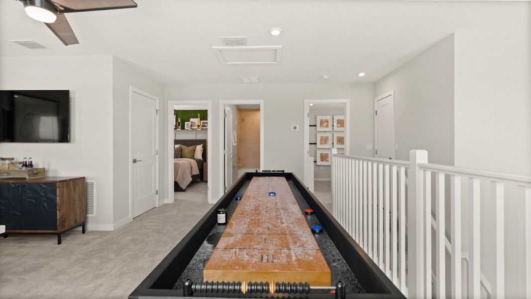 Second Floor Loft Space staged as a game room in this New Construction Home in Winter Haven by DRB Homes in Willowbrook North