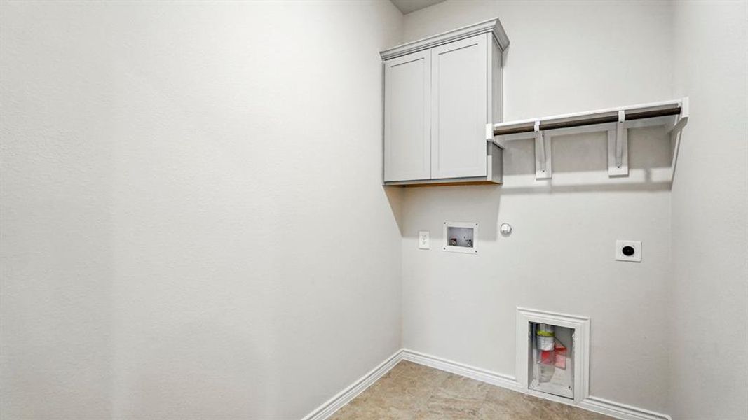 Washroom with hookup for a gas dryer, cabinet space, hookup for an electric dryer, and washer hookup