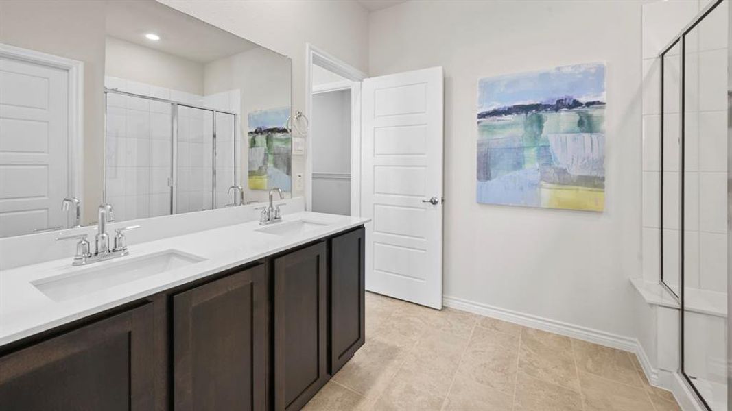 Bathroom featuring double vanity and a stall shower