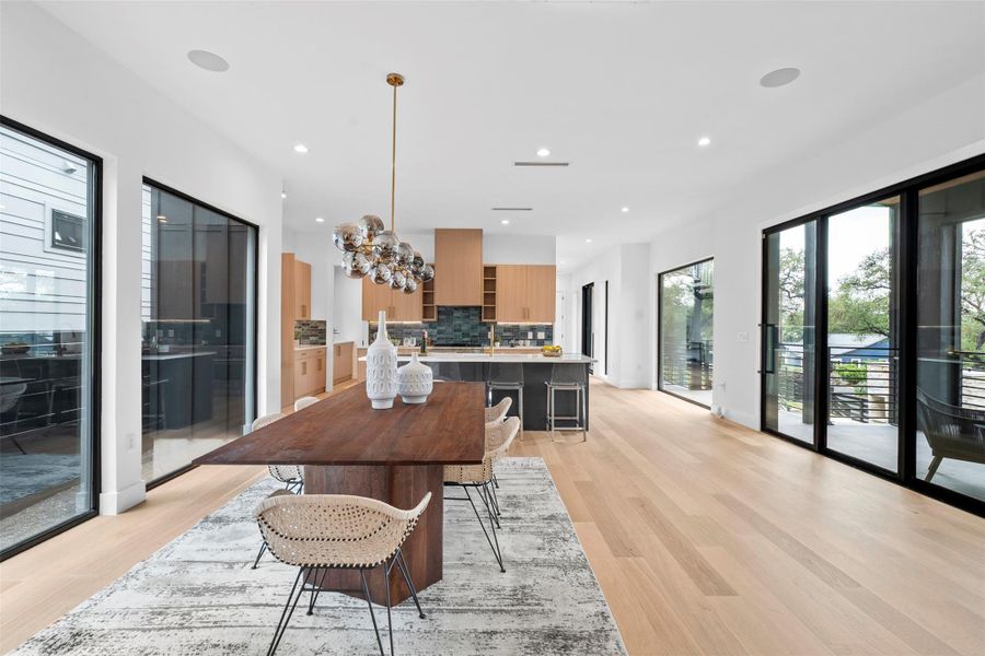 Expansive open-concept living area featuring light-toned wood flooring and recessed lighting