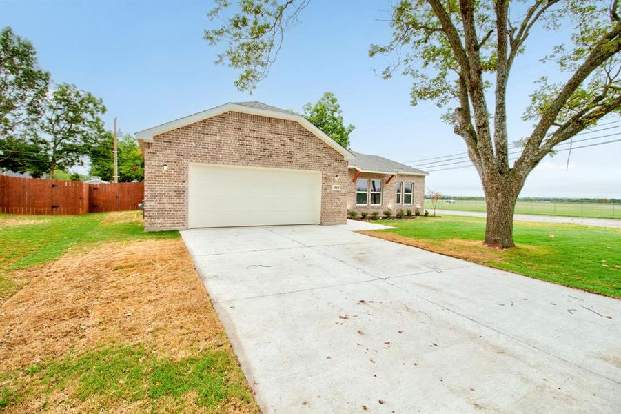 View of front of house with brick siding, driveway, and an attached garage