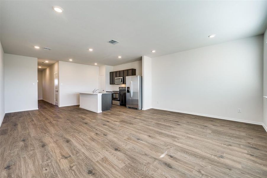 Kitchen featuring a kitchen island with sink, sink, light wood-type flooring, and appliances with stainless steel finishes