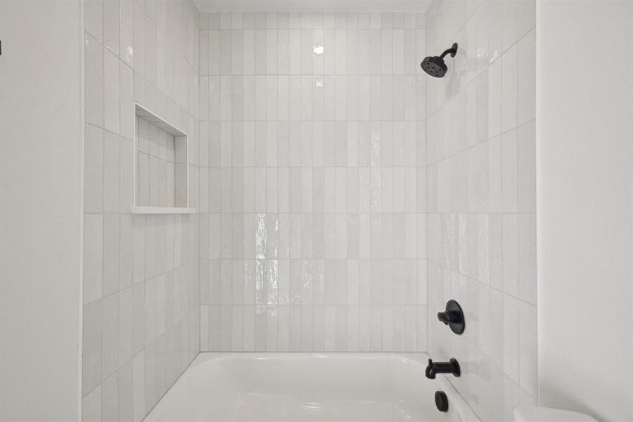 Bathroom featuring toilet and tiled shower / bath combo