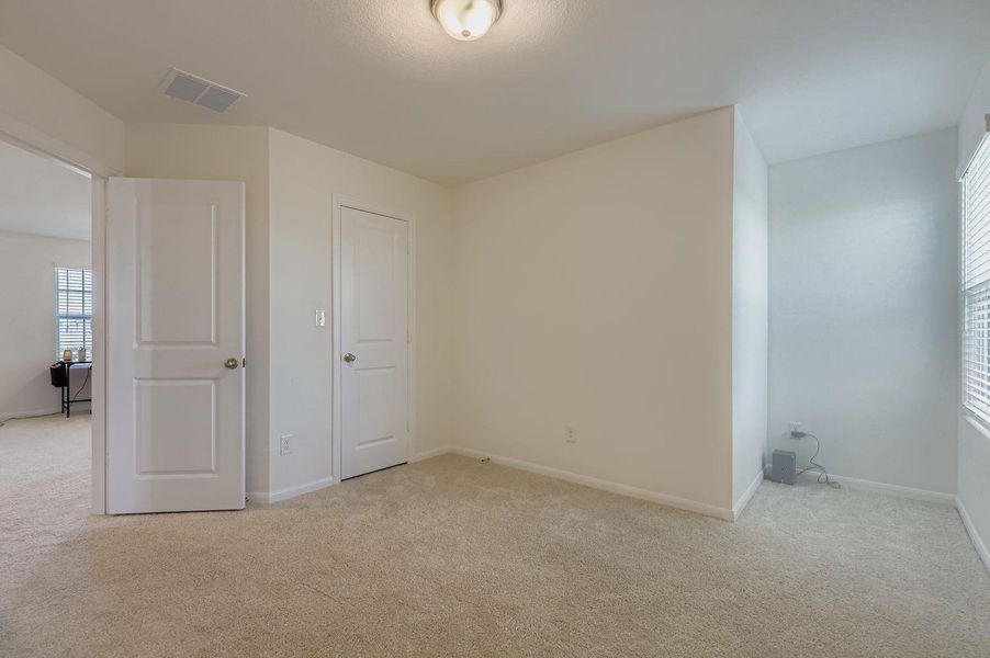 Unfurnished bedroom with light colored carpet