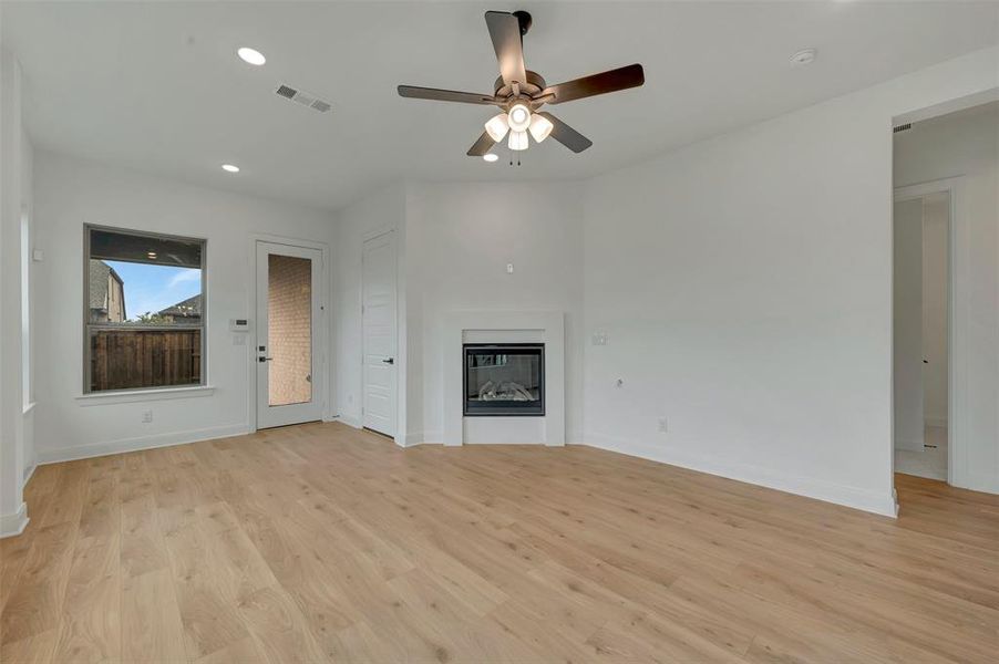Spacious interior with light wood-finish flooring, recessed lighting, and a ceiling fan