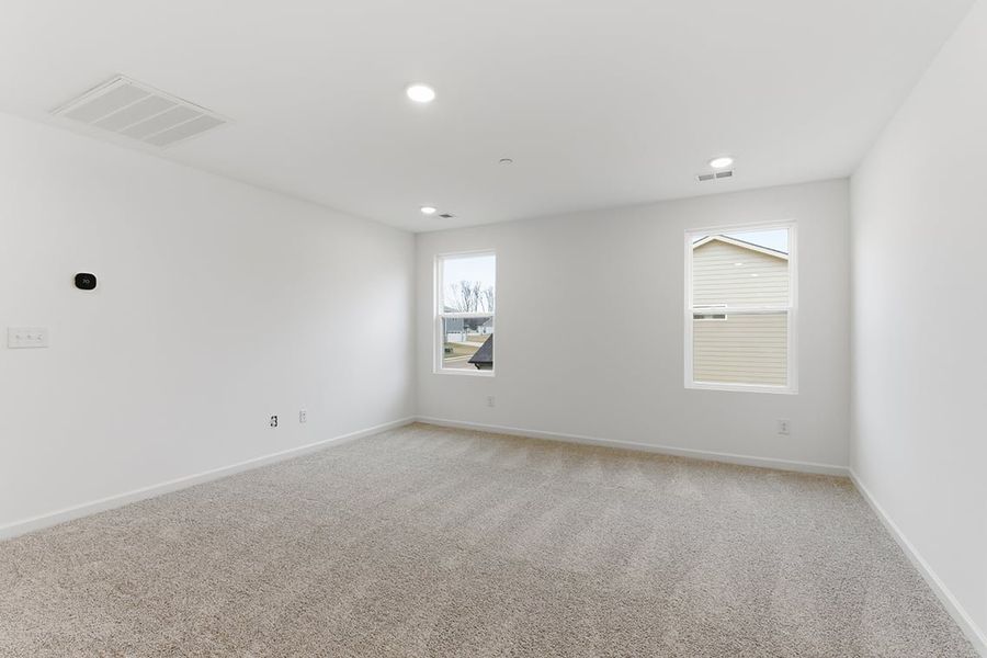 A room with a white wall and a painting on the wall.