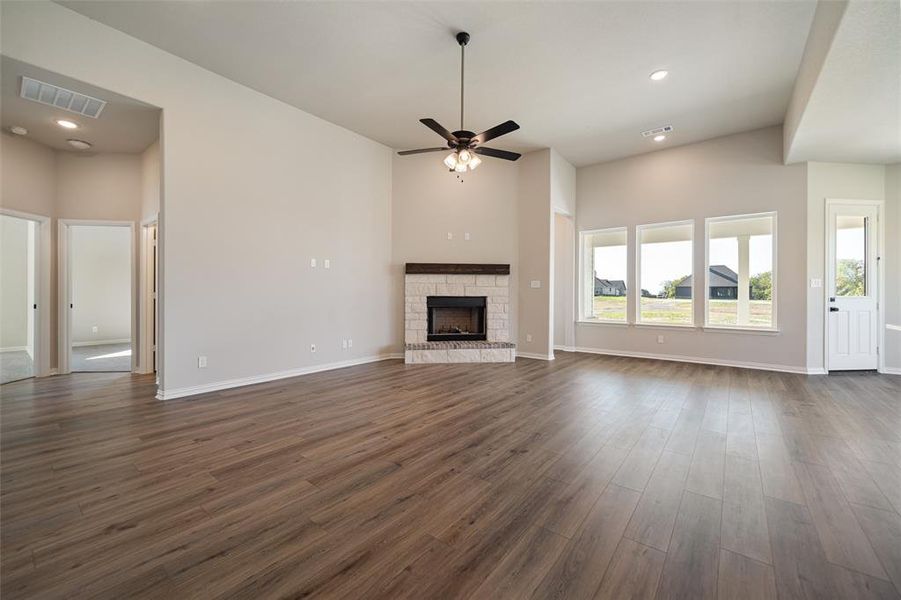 Unfurnished living room with recessed lighting, a stone fireplace, dark wood finished floors, and a ceiling fan
