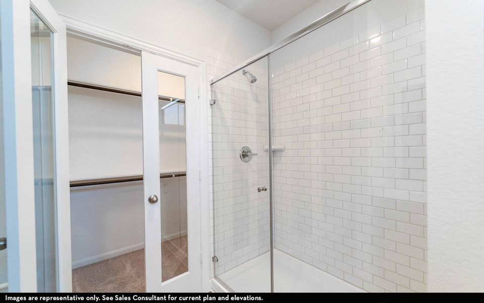 Bathroom with a walk in closet and a shower stall