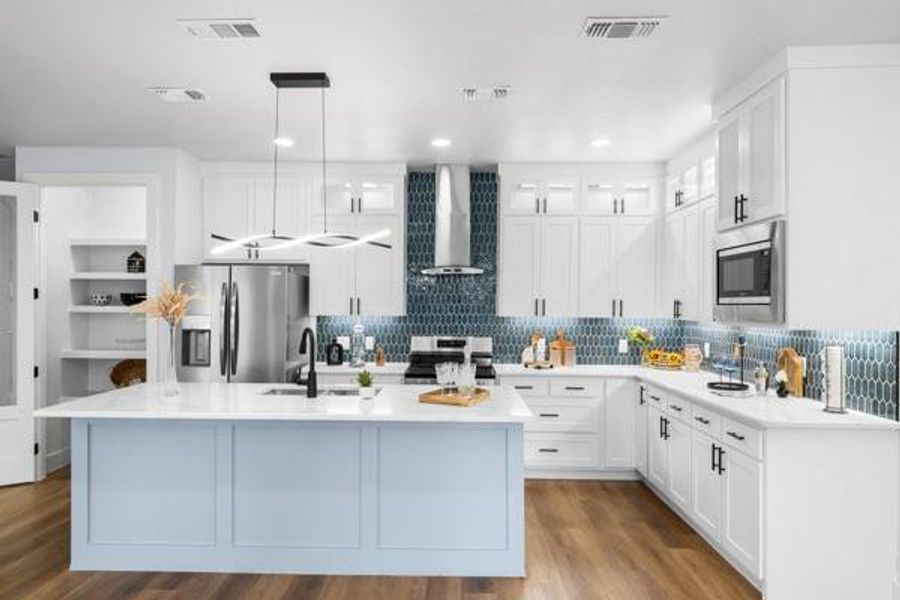 Kitchen with decorative light fixtures, white cabinetry, backsplash, stainless steel appliances, and light wood finished floors Kitchen with decorative light fixtures, white cabinetry, backsplash, stainless steel appliances, and light wood finished floors