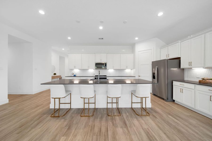 The kitchen is simply stunning, with a sleek 11' quartz island and under-cabinet lighting for a polished touch.