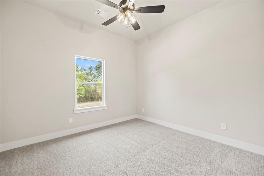 Carpeted spare room featuring baseboards and ceiling fan Carpeted spare room featuring baseboards and ceiling fan