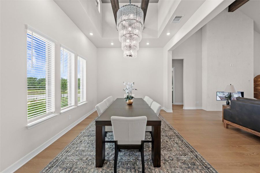 Elegant tray ceilings and an ornate tiered chandelier crown this grand dining room. Elegant tray ceilings and an ornate tiered chandelier crown this grand dining room.