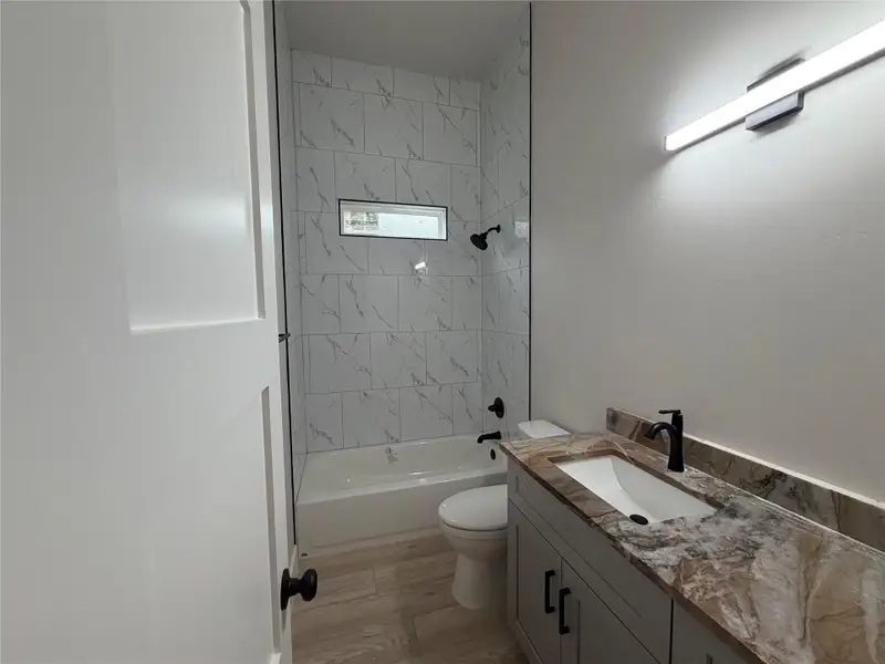 A well-appointed bathroom with a modern vanity, elegant tile work, and a practical tub-shower combination.