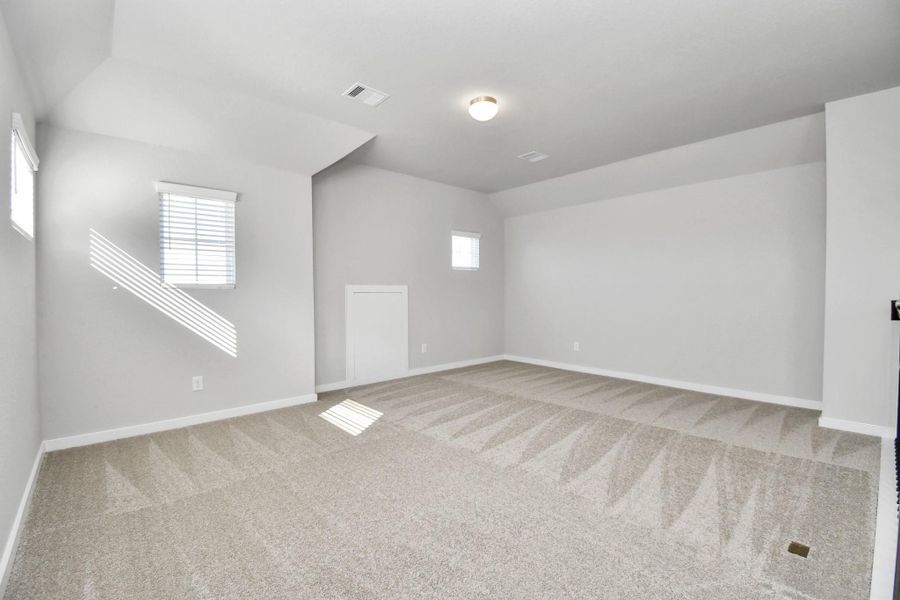 Come upstairs and relish a day of relaxation in this loft area! Ideal as an additional living space or game room, it boasts plush carpeting, high ceilings, custom paint, and windows that flood the area with abundant natural light. Sample photo of completed home with similar floor plan. Actual colors and selections may vary.