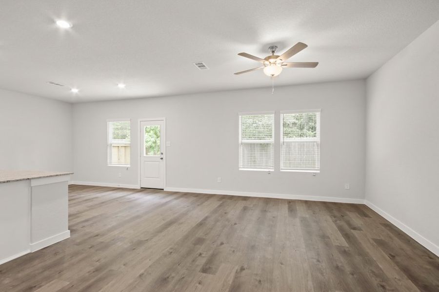 A room with a ceiling fan and a wood floor.