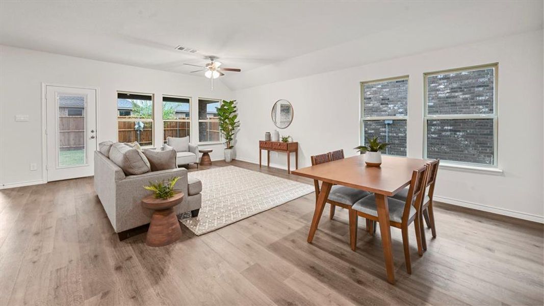 Dining space featuring a ceiling fan, light wood finished floors, and lofted ceiling