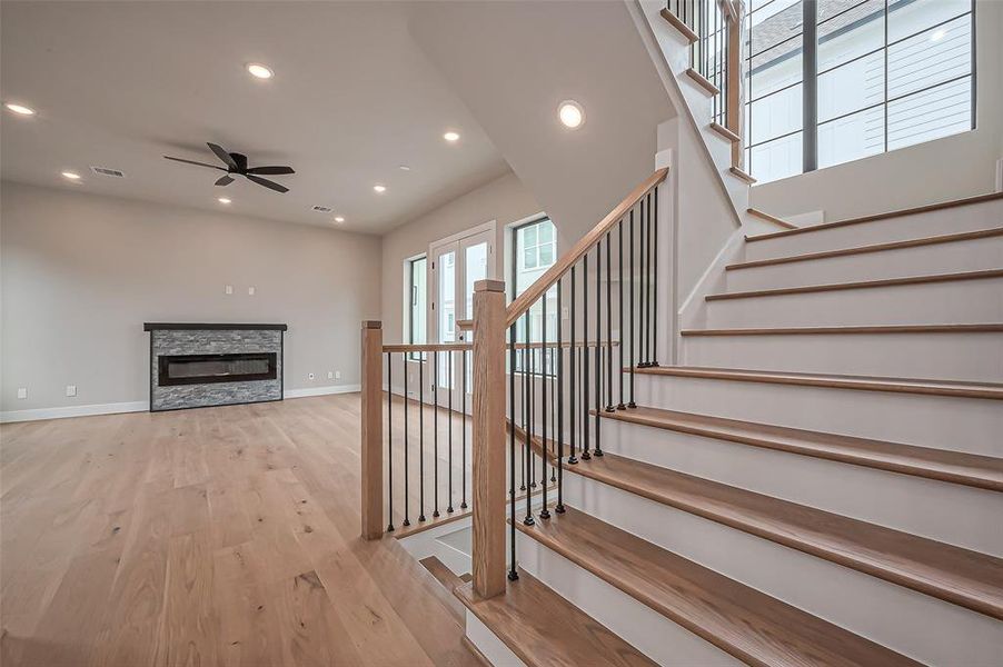 Experience this modern kitchen with sleek cabinetry, stainless steel appliances, and a central island adorned with pendant lighting. Enjoy ample counter space, a built-in desk, and elegant light hardwood floors.