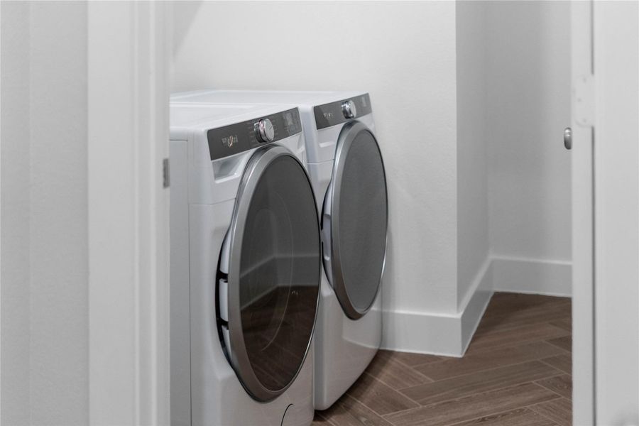 This dedicated laundry room comes equipped with a washer and dryer set, ready for immediate use.