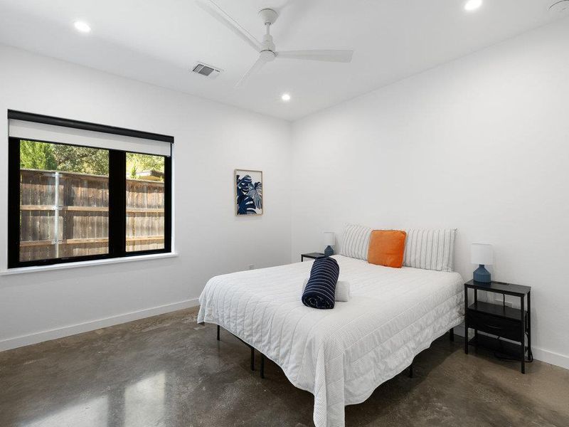 Bedroom featuring finished concrete flooring, recessed lighting, and ceiling fan