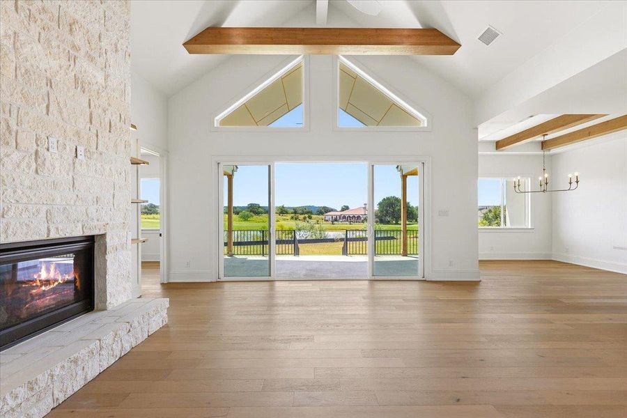 A spacious great room offers high ceilings, a cozy fireplace, and sliding doors open to expansive outdoor views. A spacious great room offers high ceilings, a cozy fireplace, and sliding doors open to expansive outdoor views.