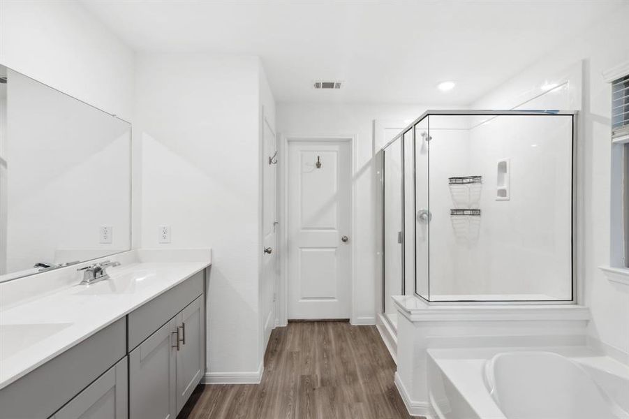 Beautiful primary bathroom with dual sinks, separate tub and shower, and a huge walk-in closet!