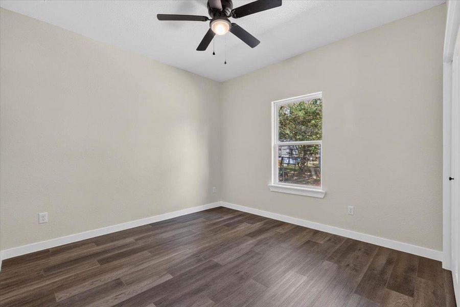 Rich wood plank flooring sets a warm foundation beneath a single window looking outdoors. Rich wood plank flooring sets a warm foundation beneath a single window looking outdoors.