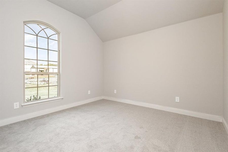 Unfurnished room with lofted ceiling and light colored carpet Unfurnished room with lofted ceiling and light colored carpet