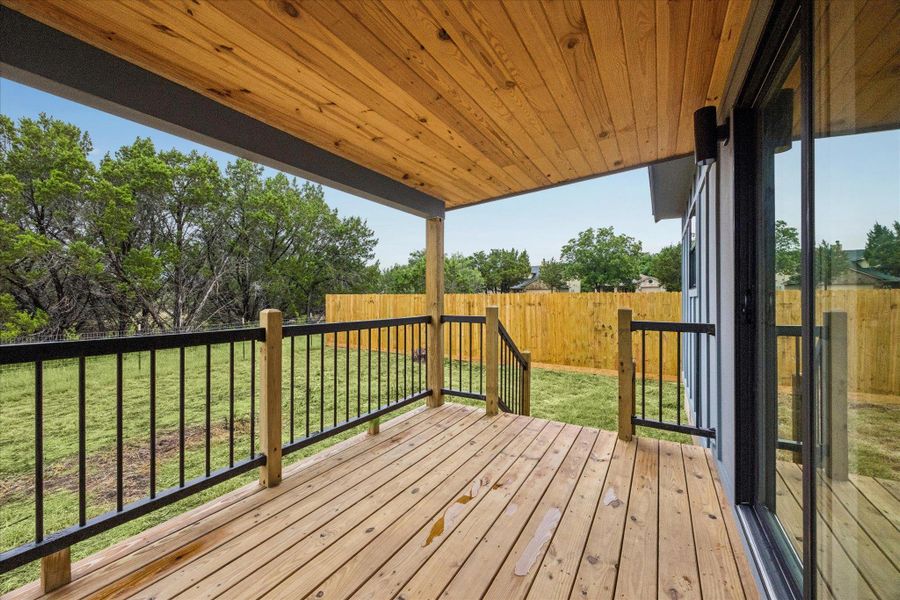 A generous wooden deck overlooks a private grassy yard, perfect for outdoor enjoyment. A generous wooden deck overlooks a private grassy yard, perfect for outdoor enjoyment.