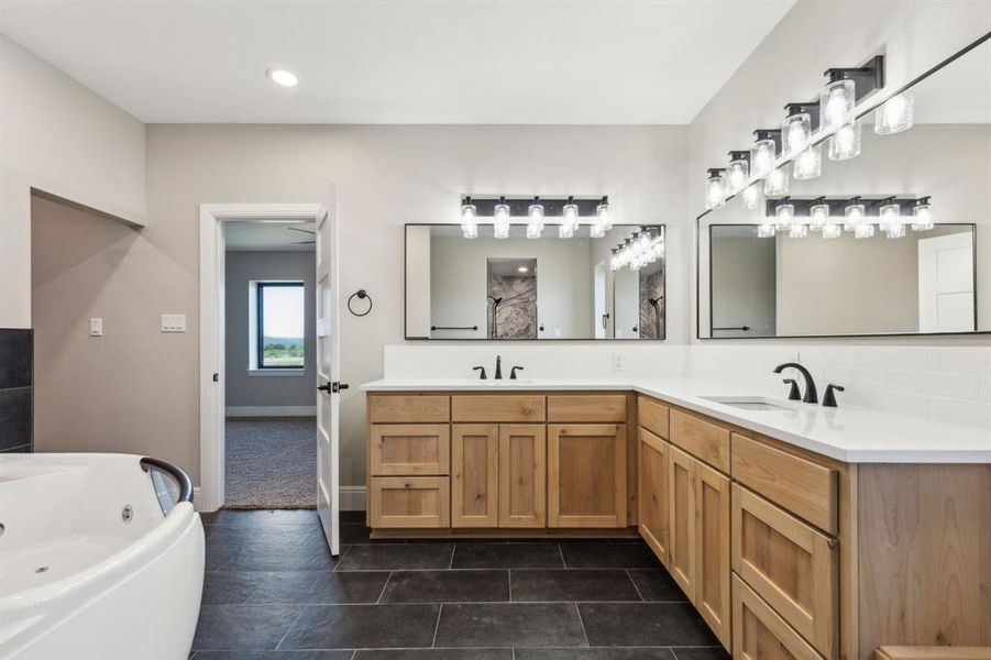 Primary bathroom with jetted tub for 2, double sink vanity, and recessed/decorative lighting. Primary bathroom with jetted tub for 2, double sink vanity, and recessed/decorative lighting.