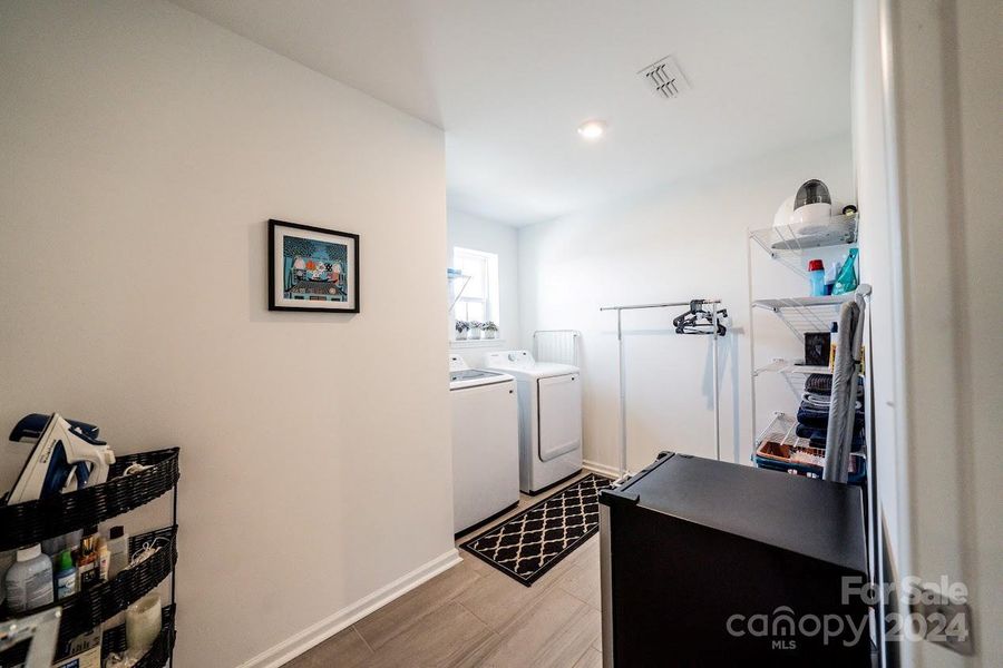 An upstairs laundry room with a window offers a lot of natural light.