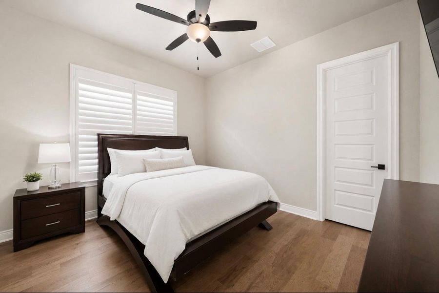 Well-lit sleeping quarters with rich hardwood flooring and ceiling fan for comfort. Well-lit sleeping quarters with rich hardwood flooring and ceiling fan for comfort.