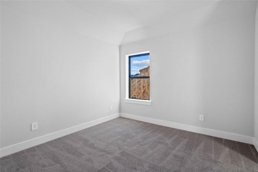This inviting secondary bedroom combines comfort and modern elegance, featuring plush carpeting, a neutral color palette, walk-in closet, and abundant natural light streaming through a large window. Added feature is the jack-n-jill secondary bathroom.