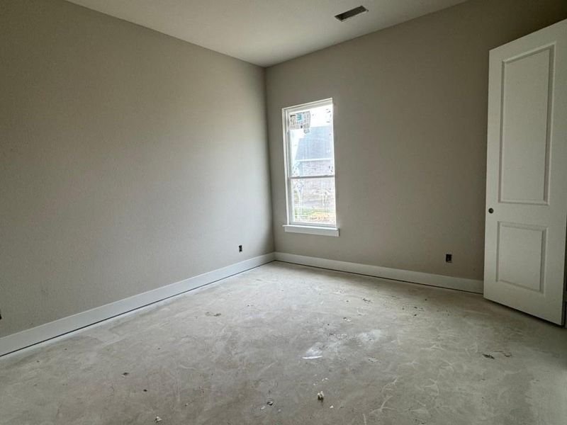 Neutral-toned walls with white trim and a single window offering natural light