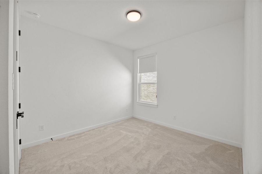 Unfurnished room featuring light carpet and baseboards