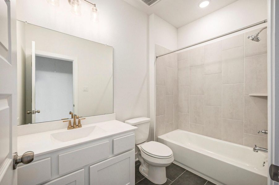 A spacious secondary bathroom is conveniently located outside of bedroom offering comfort and privacy for guests or family members. The well-appointed bath features stylish finishes and modern design, providing both function and elegance outside the primary suite.