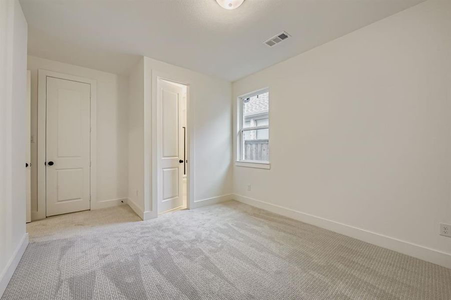 Unfurnished bedroom featuring light colored carpet and baseboards