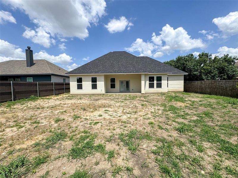 Rear view of property with a fenced backyard and french doors Rear view of property with a fenced backyard and french doors