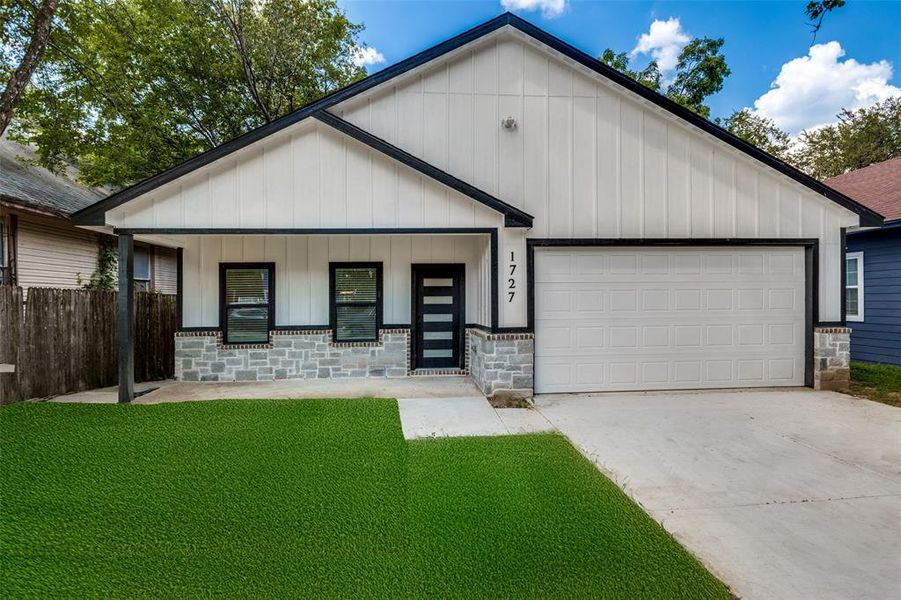 View of front of house featuring a porch, concrete driveway, board and batten siding, and a front yard View of front of house featuring a porch, concrete driveway, board and batten siding, and a front yard