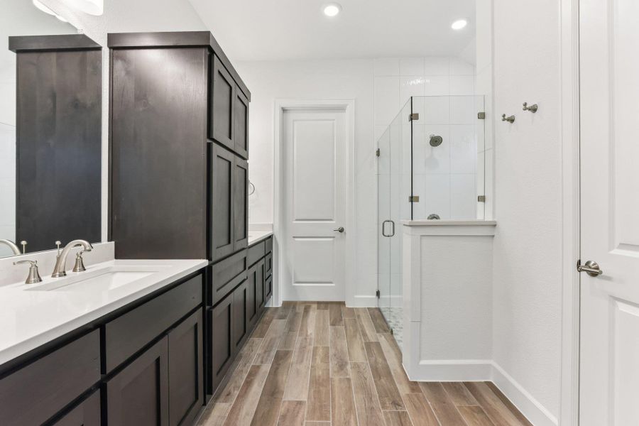Full bath with wood finish floors, vanity, a shower stall, and recessed lighting Full bath with wood finish floors, vanity, a shower stall, and recessed lighting