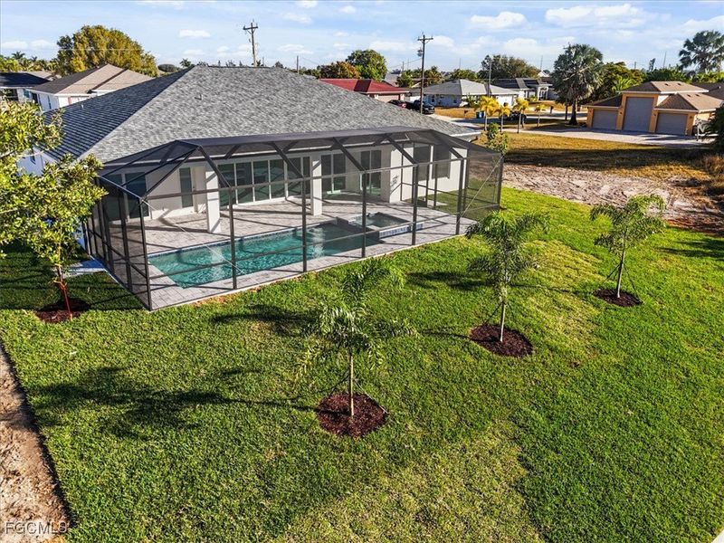 Outdoor pool with glass enclosure, a sunroom, a patio area, and a lawn Outdoor pool with glass enclosure, a sunroom, a patio area, and a lawn