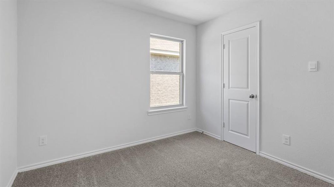 Carpeted room featuring a white paneled door, a single window, and neutral wall paint