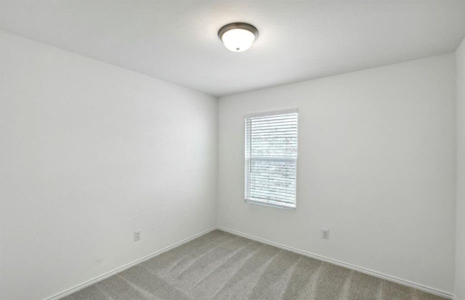 Secondary bedroom with large windows *real home pictured