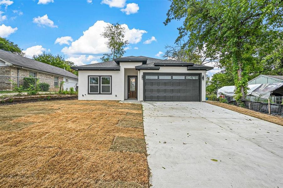 View of front of home with a garage and a front yard