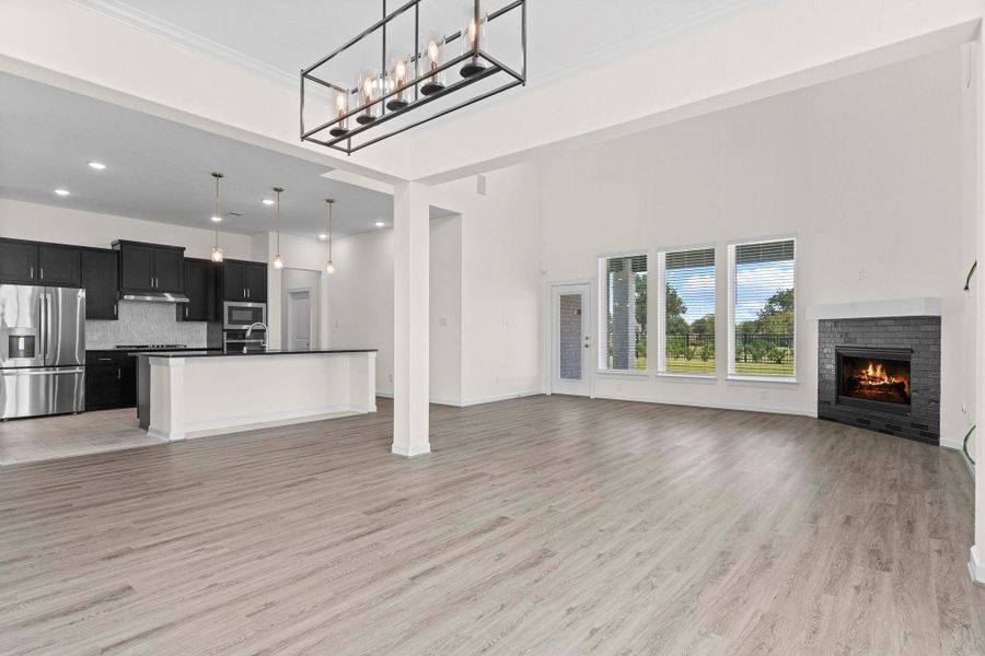 Modern kitchen seamlessly opens to the family room, featuring sleek cabinetry, breakfast bar seating, and stainless steel appliances. Modern kitchen seamlessly opens to the family room, featuring sleek cabinetry, breakfast bar seating, and stainless steel appliances.