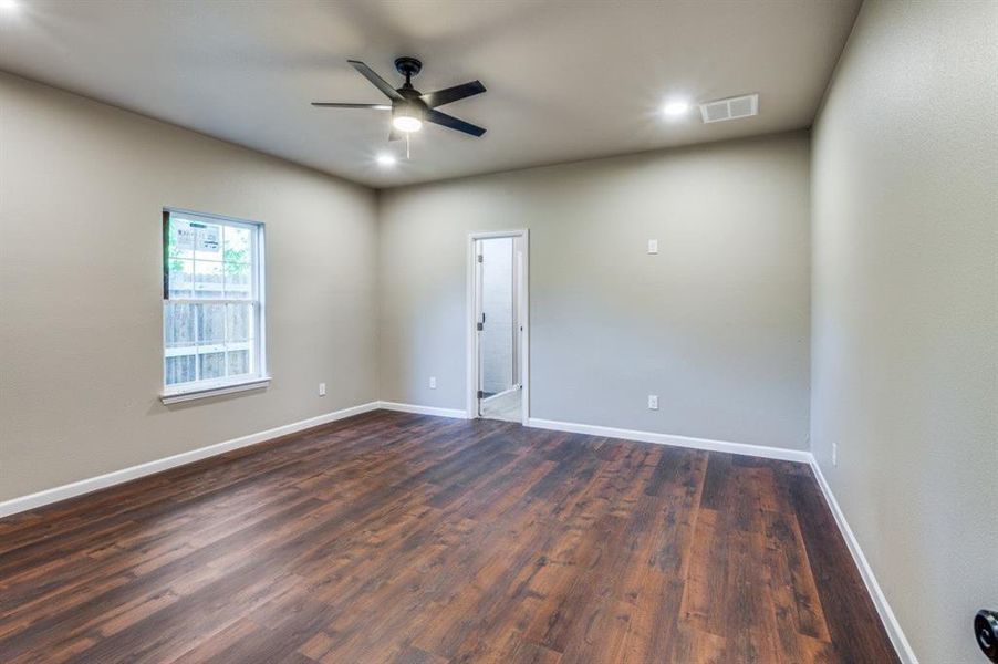 Unfurnished room with ceiling fan and dark hardwood / wood-style flooring